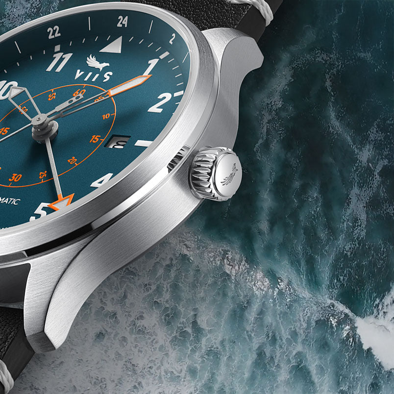 Detailansicht der VIIS Flieger GMT 42 „Adriatic“ – blaue Fliegeruhr mit Edelstahlgehäuse vor meerblauem Hintergrund, wodurch das Design und die bestechenden Details zum Ausdruck kommen.