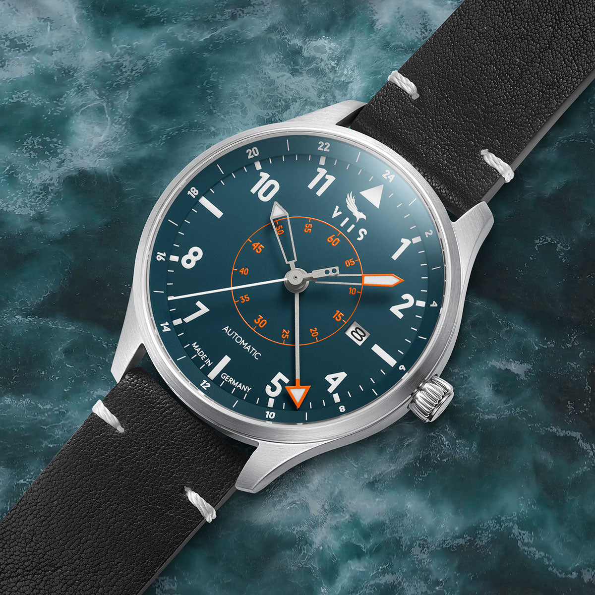 Schräge Frontansicht der VIIS Flieger GMT 42 „Adriatic“ – blaue Fliegeruhr mit Edelstahlgehäuse vor meerblauem Hintergrund, wodurch die optimale Ablesbarkeit zum Ausdruck kommt.